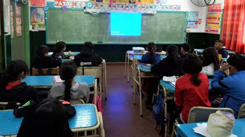 Alumnos de la Escuela 718 miran atentamente un video sobre prevención de adicciones durante la charla con Juego Responsable.