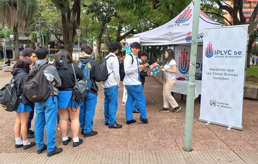 Grupo de chicos con uniforme escolar en el stand de Juego Responsable que realiza actividades en la Plaza San Martín de Posadas.