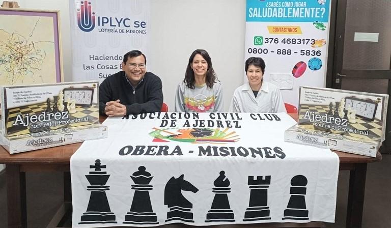 Dos organizadores del torneo junto a la titular de Juego Responsable en la entrega de los tableros de ajedrez.