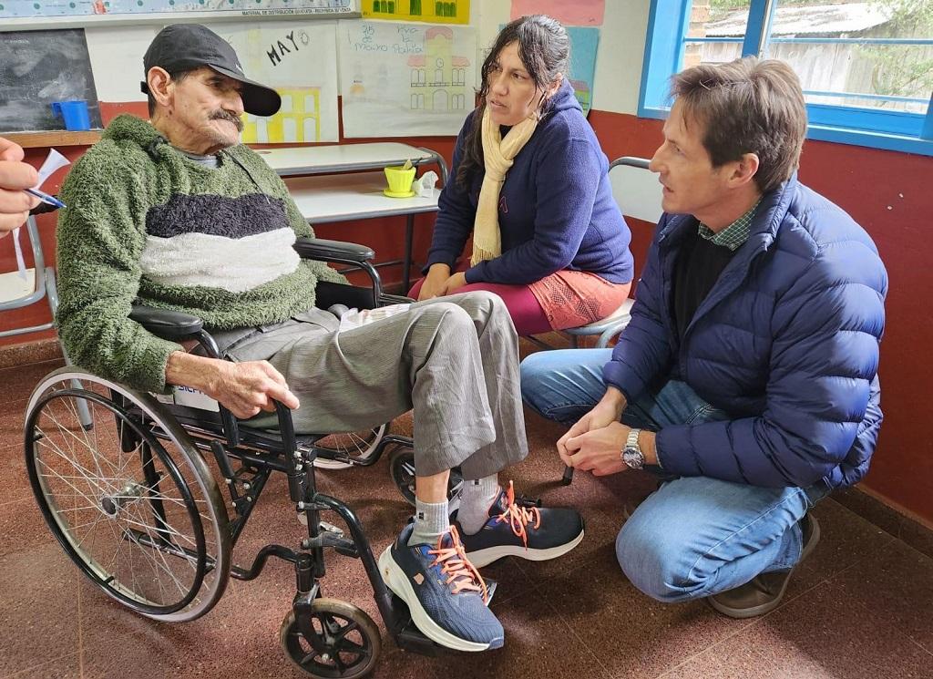 Héctor Decut charla con un vecino que se acercó al operativo de IPLyC Social Presente, en su silla de ruedas.