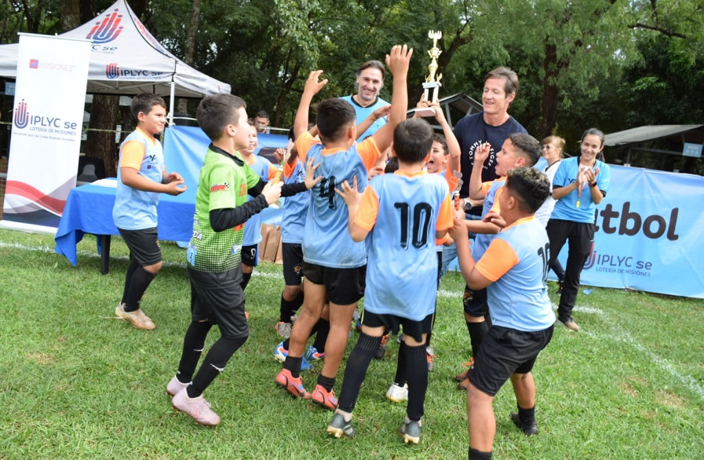 Equipo ganador de la primera Copa Amistad festeja y levanta la copa, junto a Schiavi y Decut.