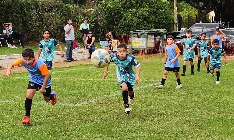 Niños en pleno juego en la cancha, durante el torneo de Vivamos Fútbol.