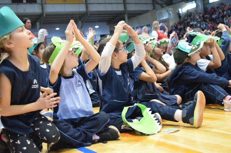 niños hacen palmas mientras disfrutan del show de la fiesta de los jardines.