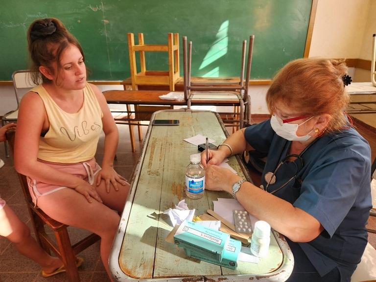 Vecina es atendida por una mujer personal de salud durante el operativo de IPLyC Social Presente.