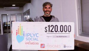 Carlos Soria, muestra su cheque sonriente. Con el dinero comprará elementos para la enseñanza de la lengua de señas.