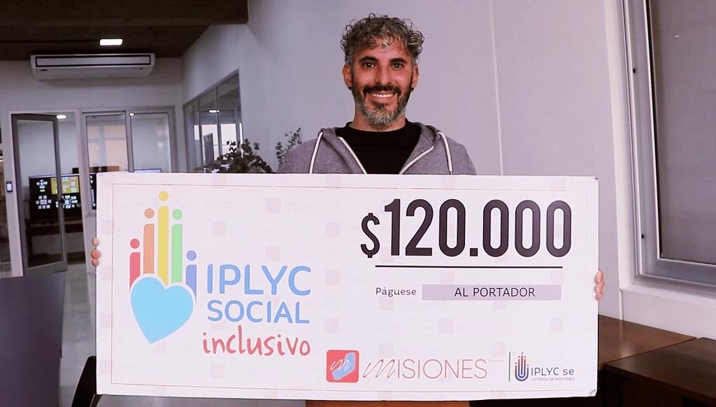 Carlos Soria, muestra su cheque sonriente. Con el dinero comprará elementos para la enseñanza de la lengua de señas.