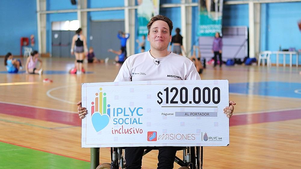Tiago Engler, ganador de IPLyC Inclusivo, muestra su cheque sonriente. Manifestó que con el dinero del premio comprará elementos deportivos para su entrenamiento.