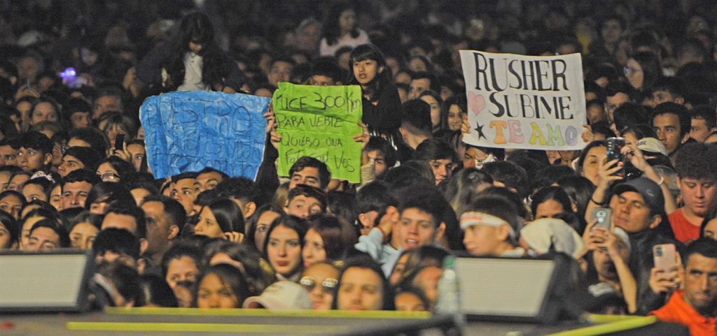 El púbico muestra sus carteles pidiendo subir al escenario, sacarse fotos con los artistas y distintos mensajes para los mismos.