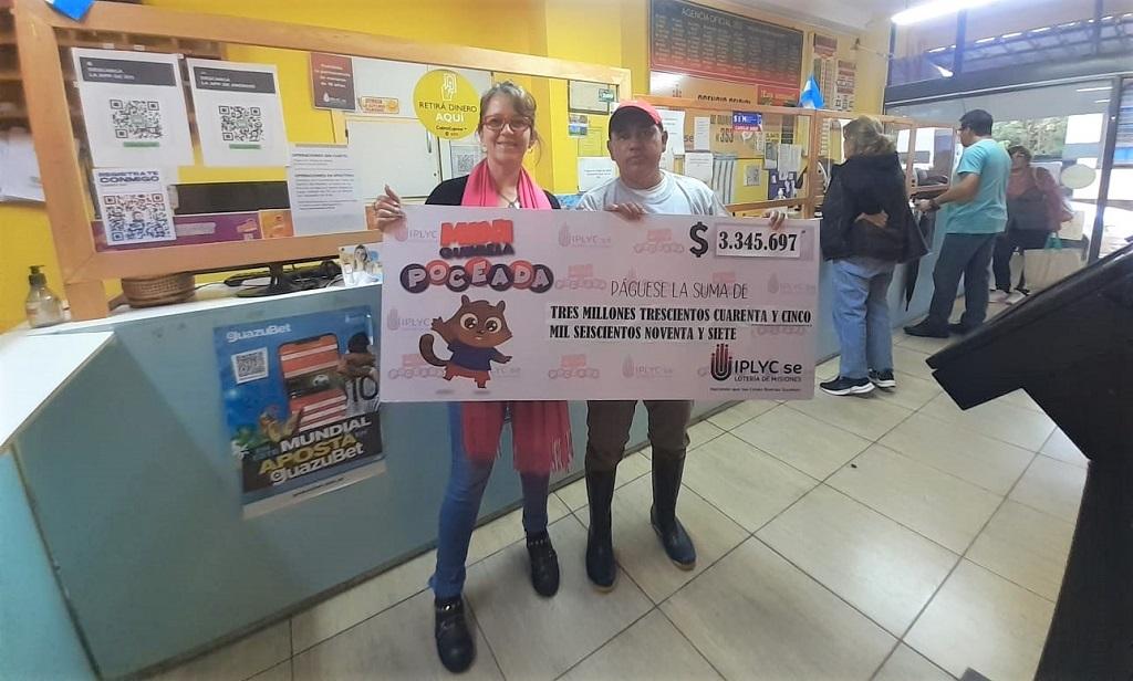 Julio Vera, vendedor que armó la jugada del ticket ganador de la Mini Poceada junto a la encargada de la Agencia 353, muestran el cheque en el local.