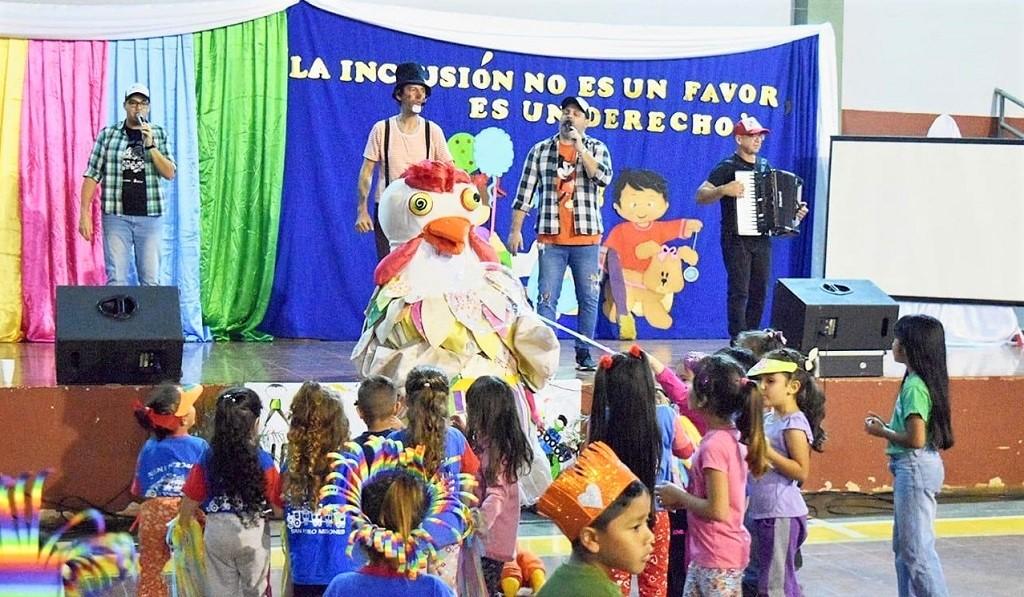 Niños interactúan con la Gallina Turuleca que está sentada sobre el borde del escenario, durante el show de Gurises Felices, que promueve la inclusión.