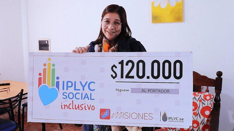 María Olivera sostiene su cheque sonriente. Usará el dinero para pagar cuentas, comprar cosas para la casa y visitar al oftalmólogo.