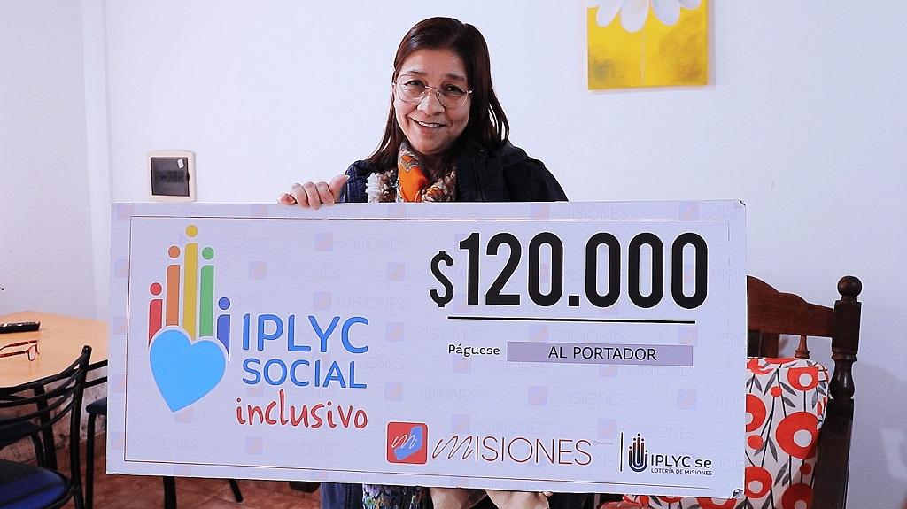 María Olivera sostiene su cheque sonriente. Usará el dinero para pagar cuentas, comprar cosas para la casa y visitar al oftalmólogo.