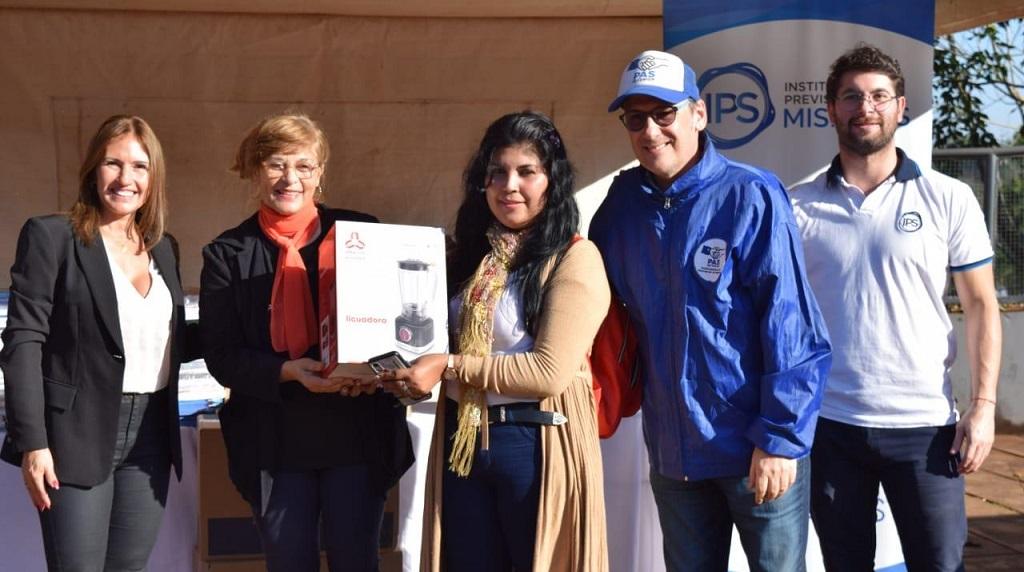Fátima Cabrera, María Boutrón y Enrique Parra, entregan un electrodoméstico a una vecina ganadora del sorteo de IPLyc Social.