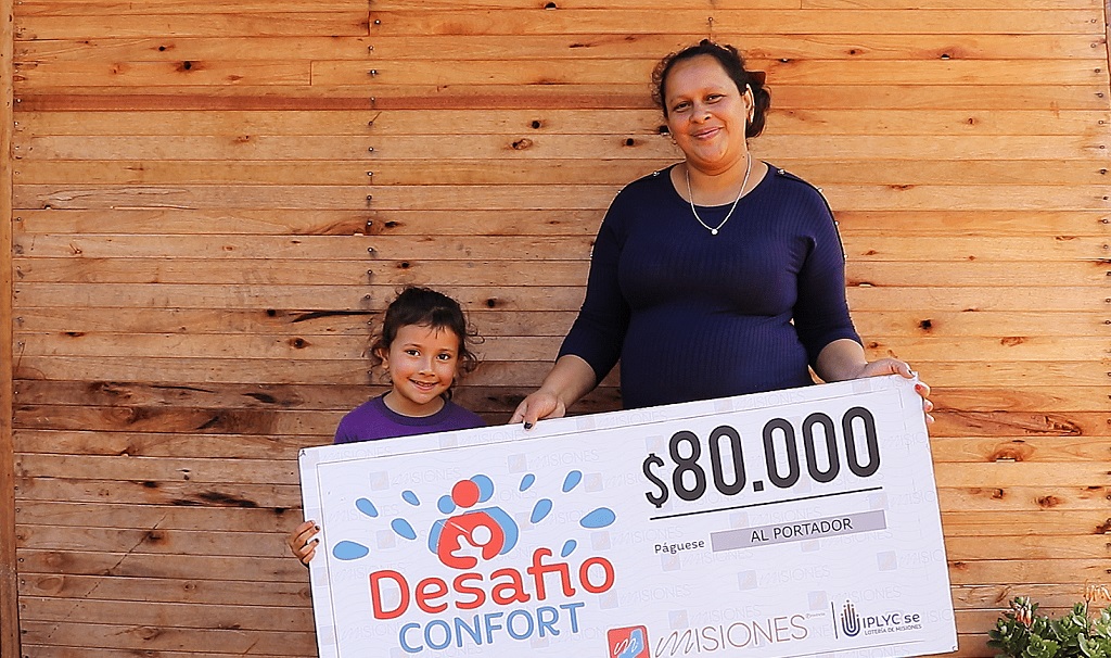 Daniela Gómez junto a su hijita muestran el cheque con una sonrisa. Dijo que "el premio llegó en el momento justo".