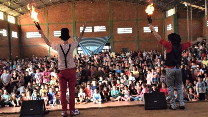 Poca Sopa y Tata Pó (de espaldas sobre el escenario) saludan al público con las antorchas en alto.