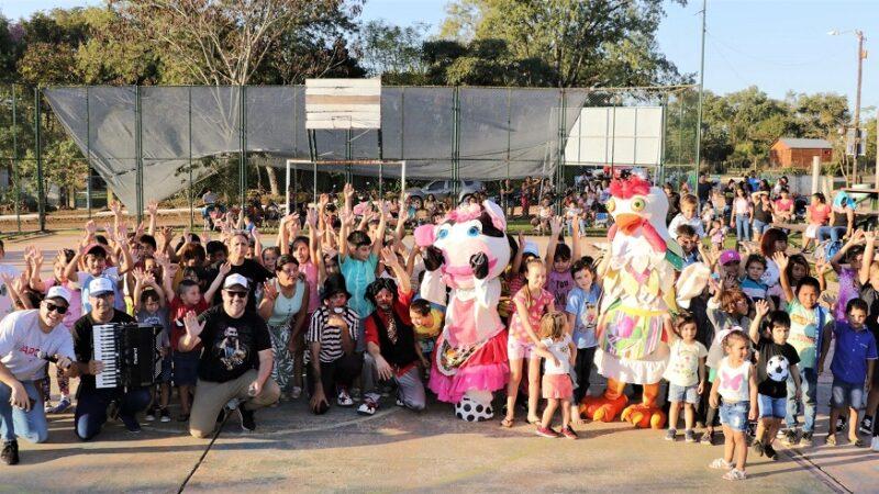 Niños y equipo de Gurises Felices saludan sonrientes en el playón del deportivo durante los festejos del cumpleaños de Profundidad.