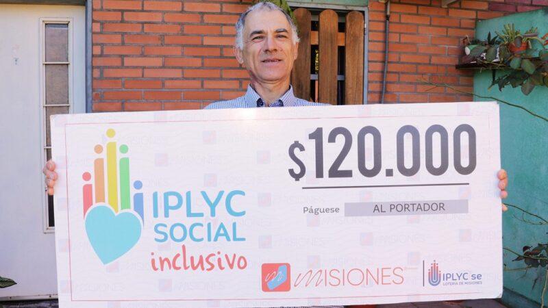 Bejnamín Ferreira muestra su cheque sonriente frente a su casa. Con el dinero hará arreglos en la casa y un regalo para su nieta.