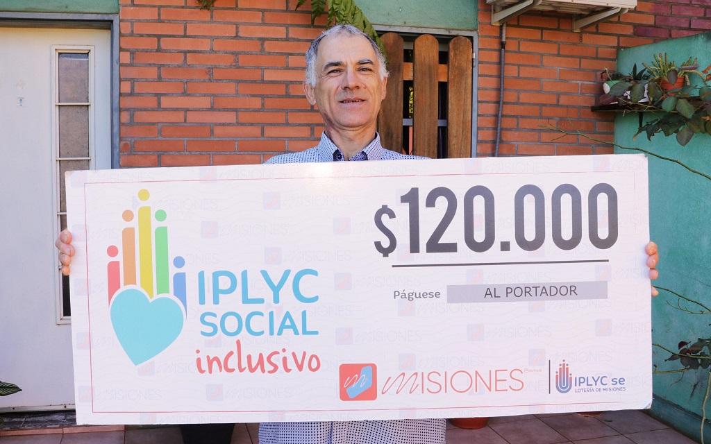 Bejnamín Ferreira muestra su cheque sonriente frente a su casa. Con el dinero hará arreglos en la casa y un regalo para su nieta.