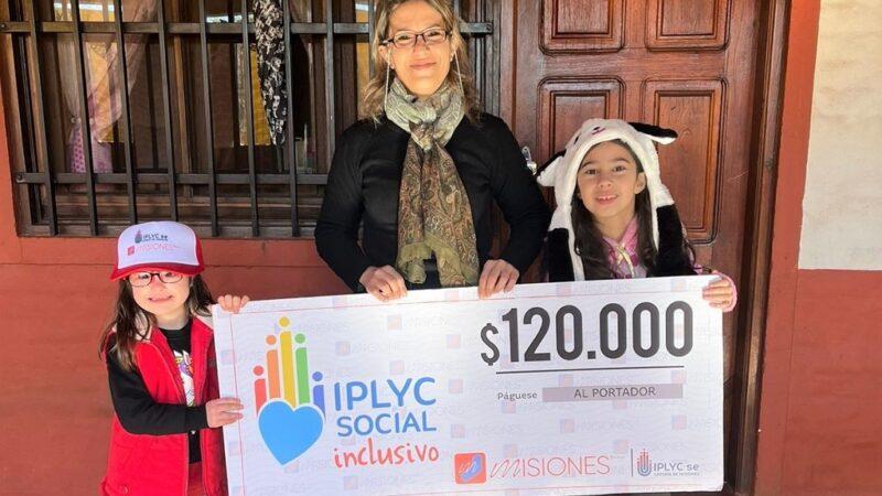 Maitena, su mamá y su hermana muestran felices su cheque. Lo usarán para pagar las terapias de Maitena.