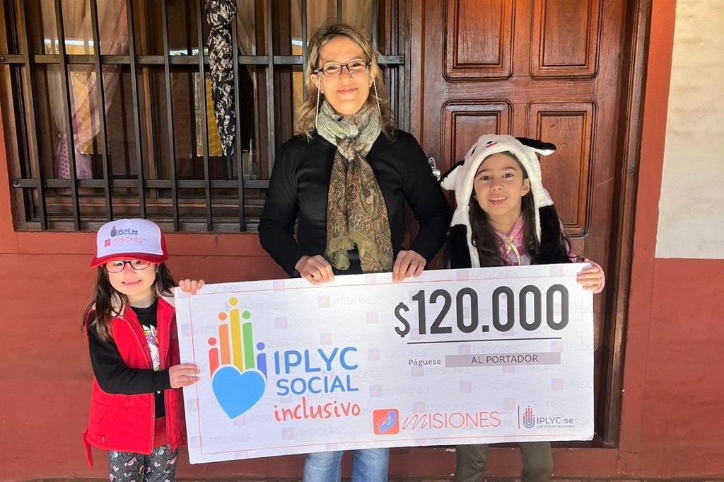 Maitena, su mamá y su hermana muestran felices su cheque. Lo usarán para pagar las terapias de Maitena.