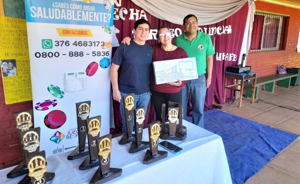 Tres de los organizadores del Torneo de Ajedrez Grand Prix muestran los tableros y premios que se entregarán en la final del tornero en Oberá.