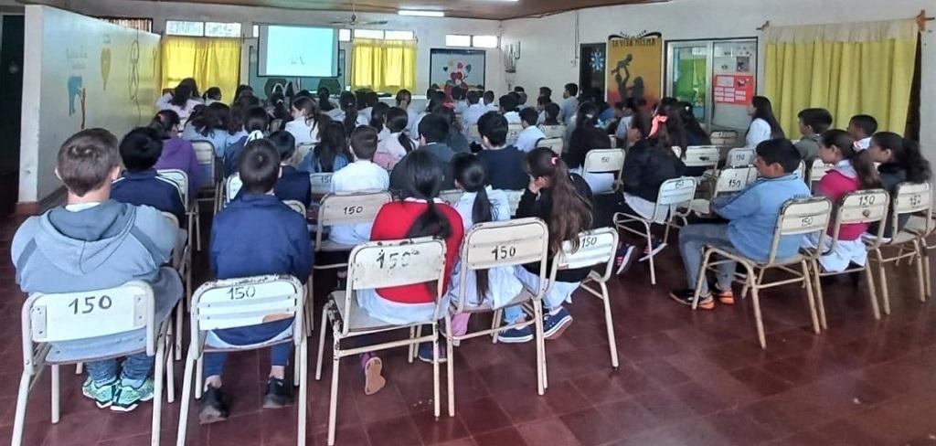 Alumnos de sexto y séptimo grado de la Escuela 150 miran video durante las charlas de prevención.