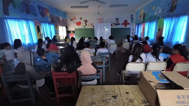 Alumnos de la Escuela 126 miran atentos un video durante charla de prevención de adicciones.