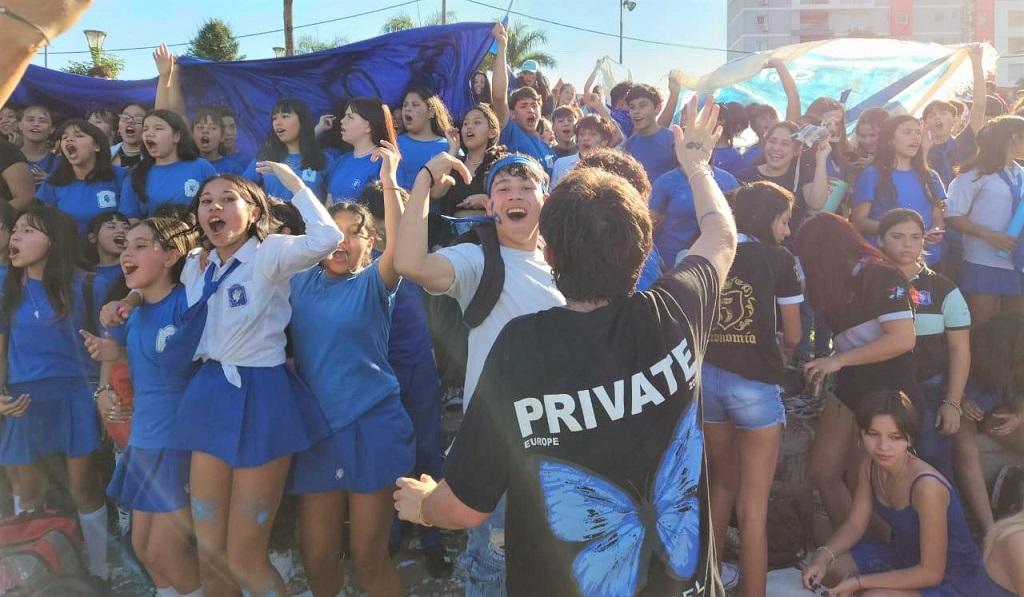 Estudiantes con sus banderas festejan saltando y cantando en grupo el lanzamiento del bono estudiantil.