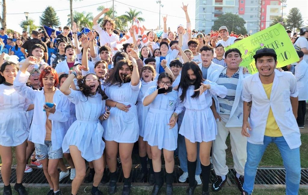 Estudiantes con sus banderas festejan saltando y cantando.