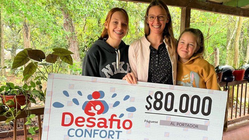 Herna y sus dos hijas felices con su cheque. El dinero será para los estudios de su hija mayor.