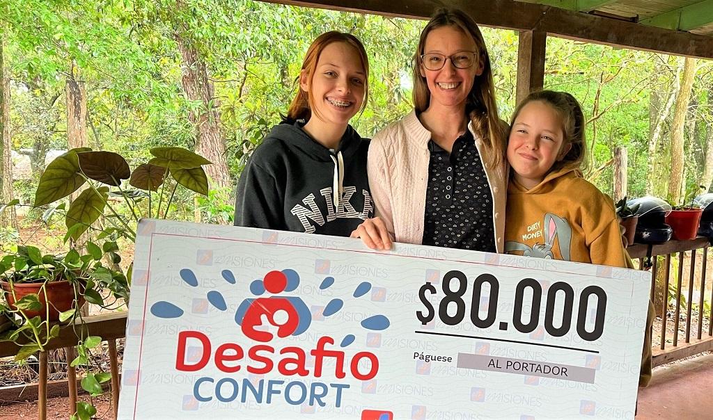 Herna y sus dos hijas felices con su cheque. El dinero será para los estudios de su hija mayor.