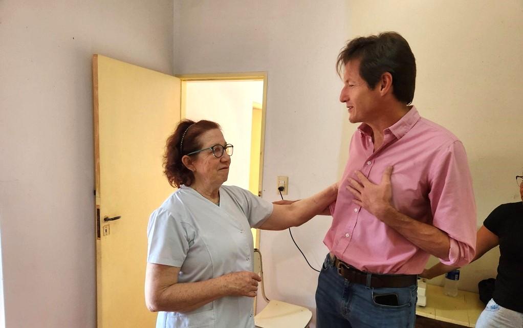 Héctor Decut y una docente charlan animadamente durante el operativo Estamos con vos.