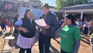 Héctor Decut lee una nota junto a dos colaboradoras del operativo Estamos con vos.