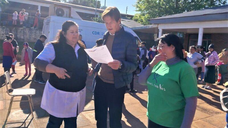 Héctor Decut lee una nota junto a dos colaboradoras del operativo Estamos con vos.