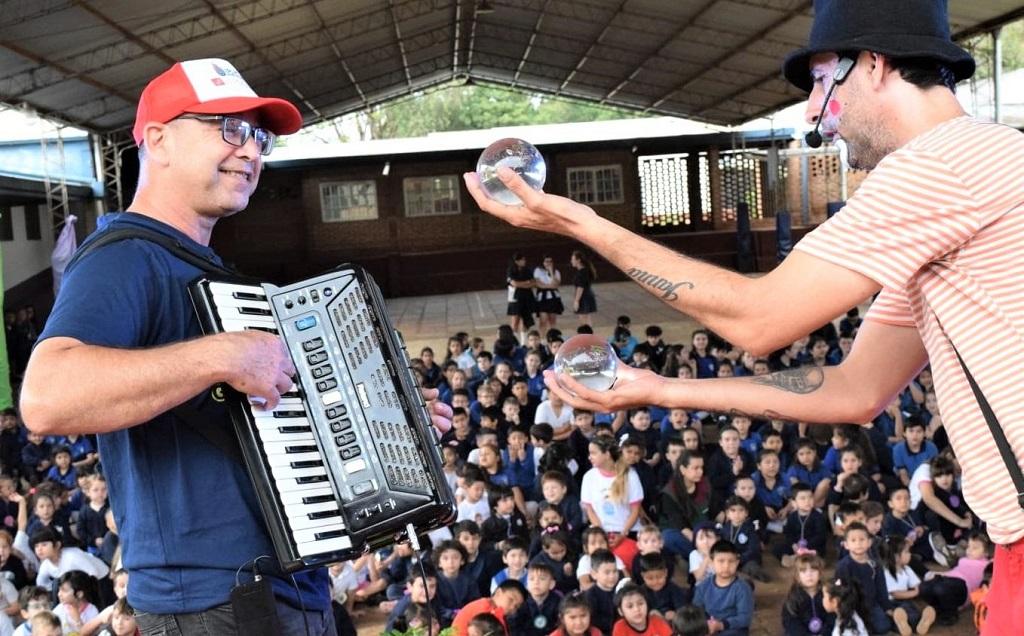 Poca Sopa hace malabares con pelotas de vidrioacompañado de un acordeonista, frente al público infantil.