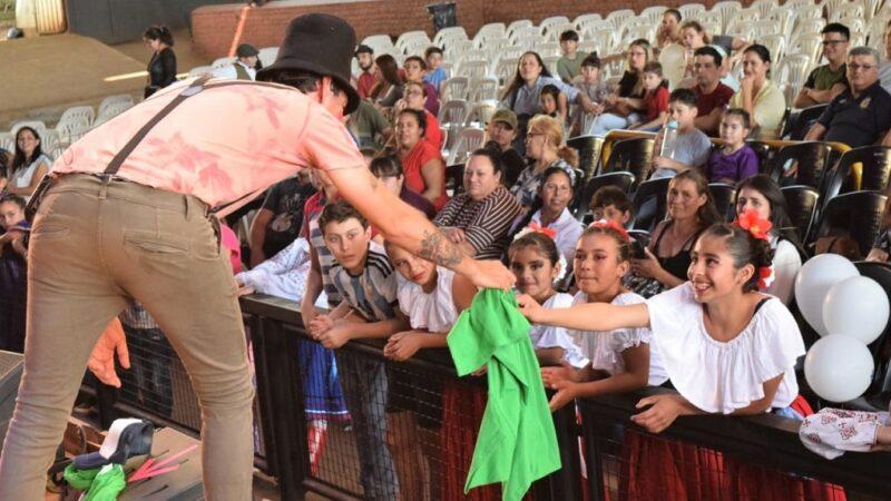 Poca Sopa entrega una remera a niña del público vestida con su traje típico.