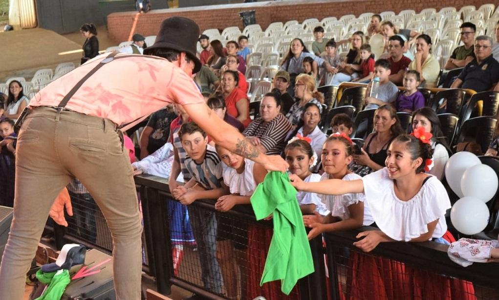 Poca Sopa entrega una remera a niña del público vestida con su traje típico.