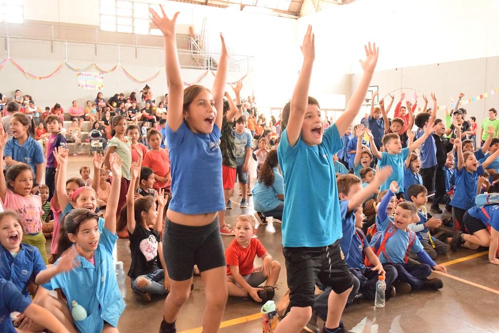 Niños del público saltan y aplauden felices con las palmas en alto. Cierre de Gurises Felices por la infancia misionera.