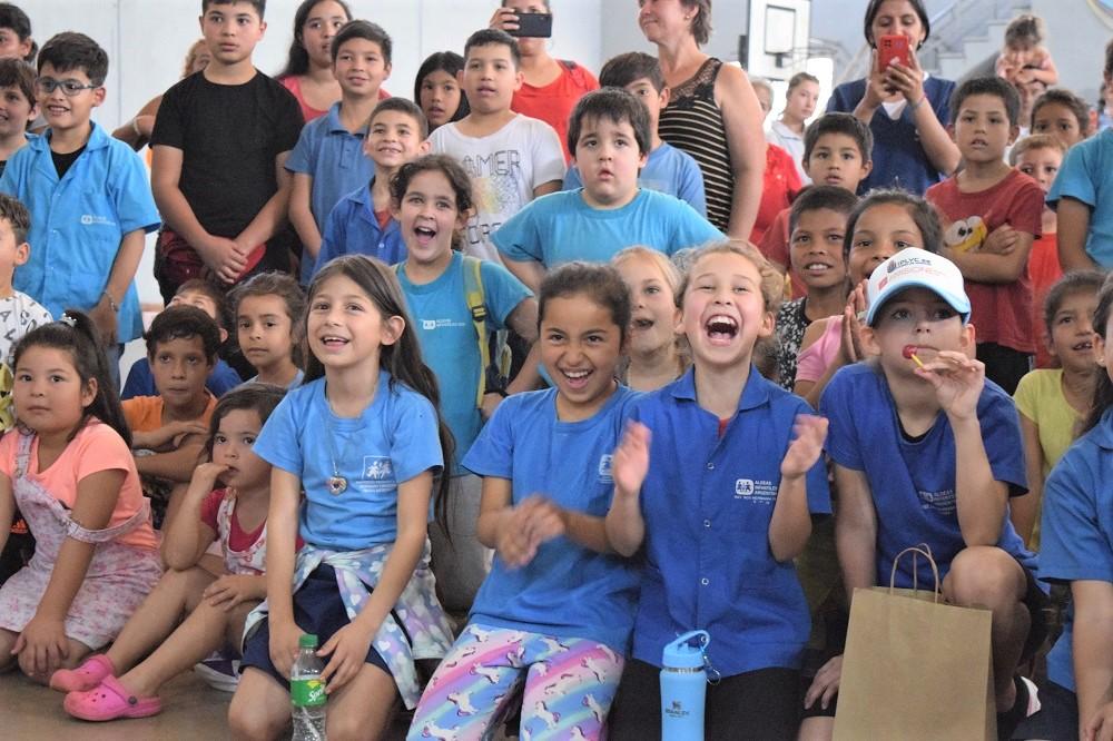 Niños del público ríen a carcajadas y aplauden.