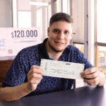Lucas Balbuena, muestra sonriente su cheque. Invertirá el dinero en elementos para su carpintería.