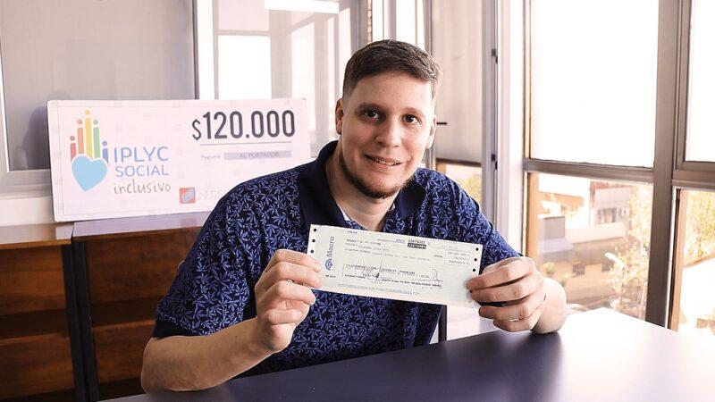 Lucas Balbuena, muestra sonriente su cheque. Invertirá el dinero en elementos para su carpintería.