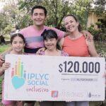 Rosana abrazada por su familia, y feliz, muestra su cheque.