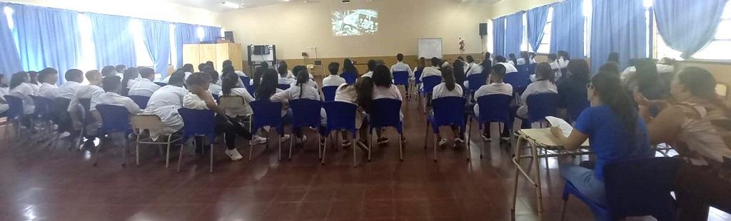 Alumnos miran video durante la charla de prevención de adicciones.