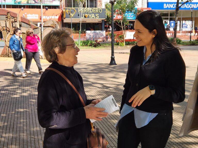 Gabriela Peralta charla con una señora mayor en la plaza.