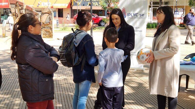 Gabriela Peralta y María Díaz Beltrán realizan juego con pelota junto a dos niños durante la intervención urbana en plaza 9 De Julio.
