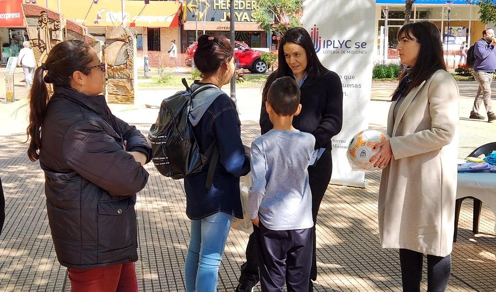 Gabriela Peralta y María Díaz Beltrán realizan juego con pelota junto a dos niños durante la intervención urbana en plaza 9 De Julio.