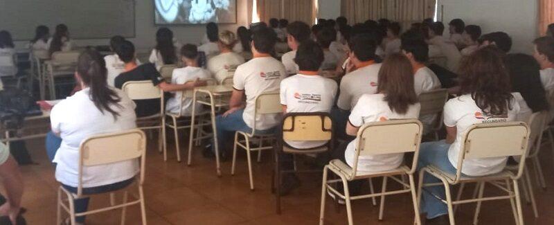 Alumnos del Instituto Kolping miran video durante charla de prevención de adicciones.