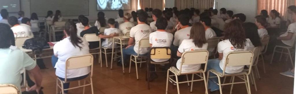 Alumnos del Instituto Kolping miran video durante charla de prevención de adicciones.