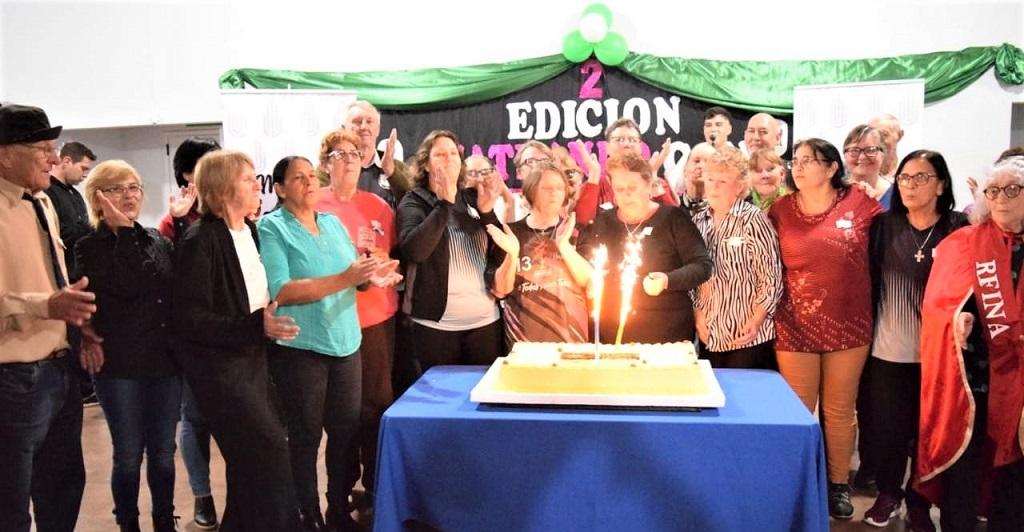 Grupo de abuelos de San Vicente soplan las velitas alrededor de una torta.