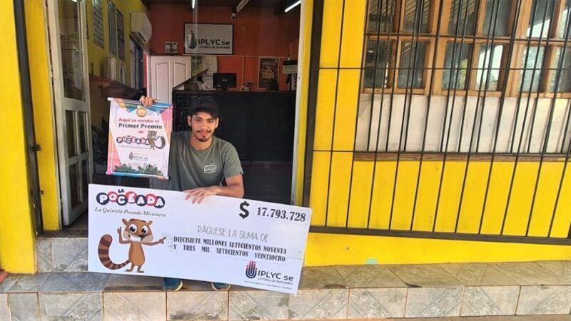 Marcelo Valenzuela, vendedor del primer premio, muestra el cheque sentado en la puerta de la Agencia.